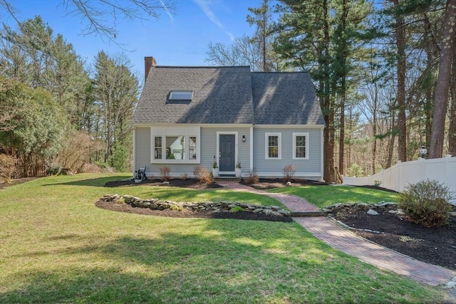 cape cod house featuring fence, a shingled roof, a front lawn, and a chimney