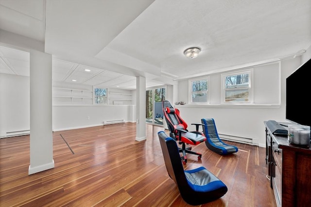 exercise area with baseboard heating, baseboards, wood finished floors, and recessed lighting