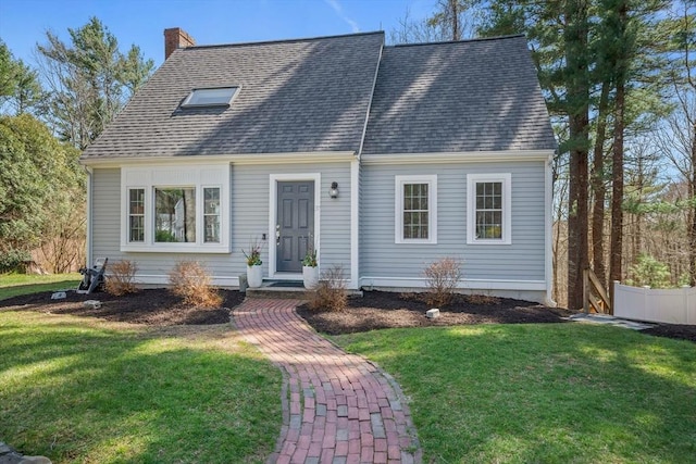 cape cod home featuring a shingled roof, a front lawn, and a chimney