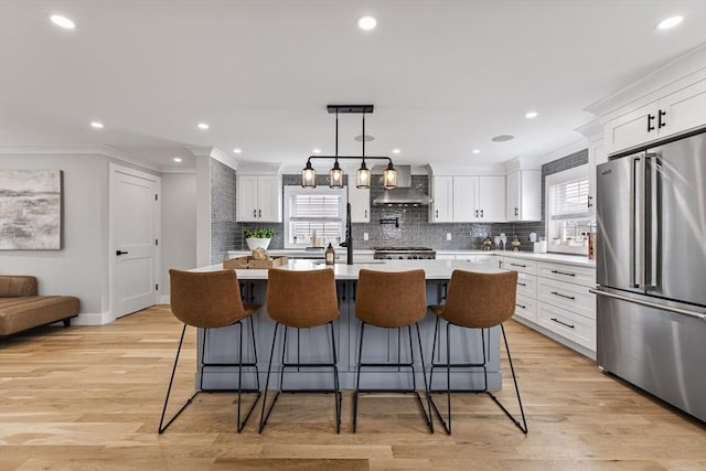 1 Wall St, Quincy, MA 02169 - kitchen featuring high end fridge, plenty of natural light, wall chimney range hood, light countertops, and crown molding