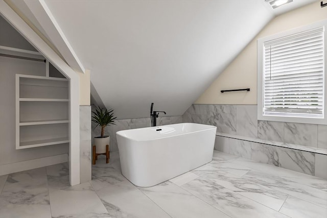 1 Wall St, Quincy, MA 02169 - full bathroom featuring tile walls, marble finish flooring, a freestanding tub, vaulted ceiling, and a wainscoted wall