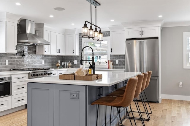 1 Wall St, Quincy, MA 02169 - kitchen featuring appliances with stainless steel finishes, wall chimney range hood, white cabinets, tasteful backsplash, and recessed lighting