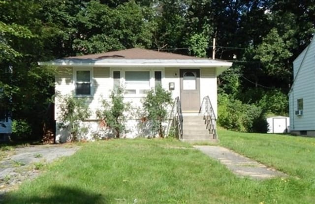 bungalow-style home featuring a front yard