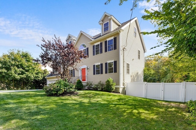 colonial house featuring a garage and a front yard