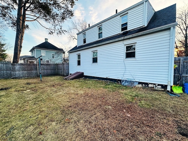 rear view of house featuring a lawn