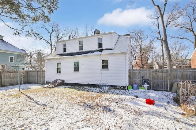 view of snow covered rear of property