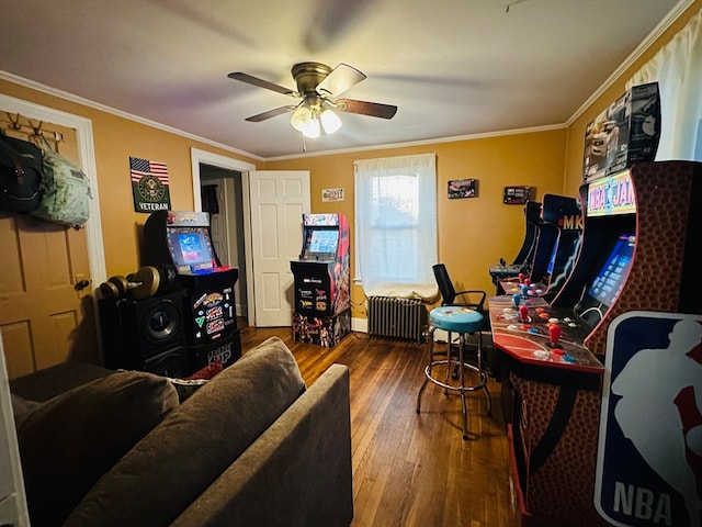 interior space with ceiling fan, radiator heating unit, ornamental molding, and hardwood / wood-style flooring