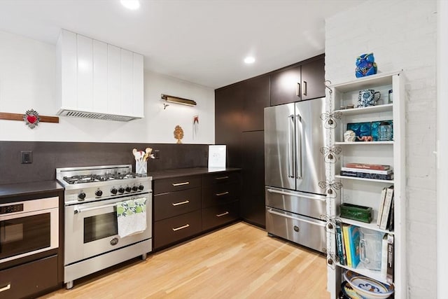 kitchen featuring high end appliances, light wood-type flooring, premium range hood, modern cabinets, and open shelves