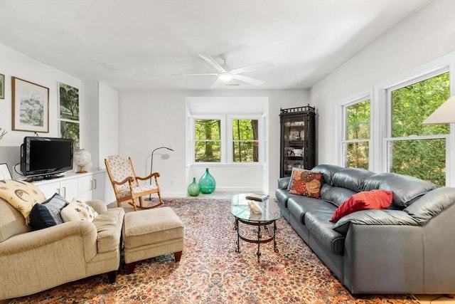 living room featuring a ceiling fan, carpet flooring, and baseboards