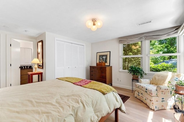 bedroom featuring light wood-style floors, baseboards, and a closet