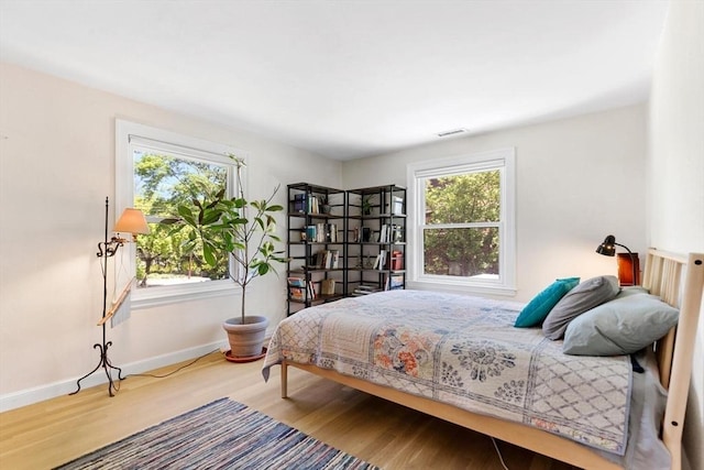 bedroom featuring wood finished floors and baseboards