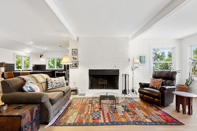 living area featuring a brick fireplace and wood finished floors