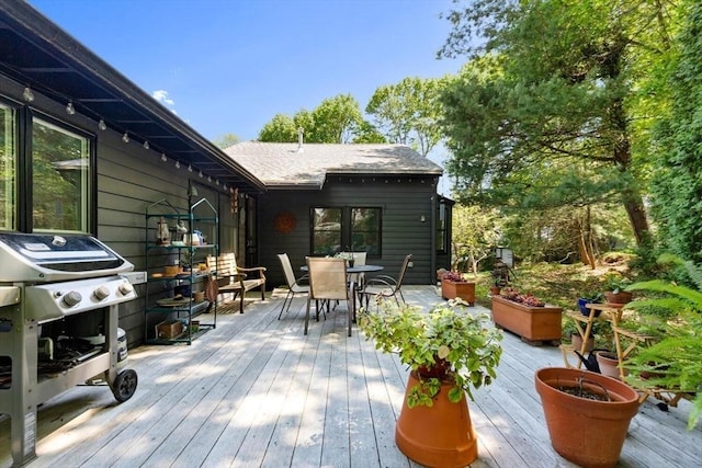 deck with outdoor dining space and a grill
