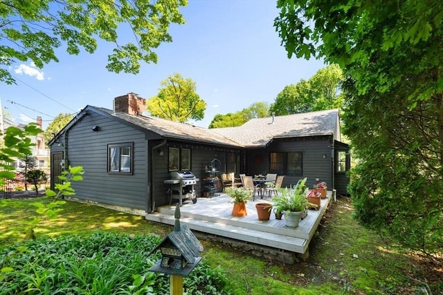 back of house featuring a deck and a yard