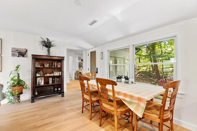 dining room with vaulted ceiling and light wood finished floors