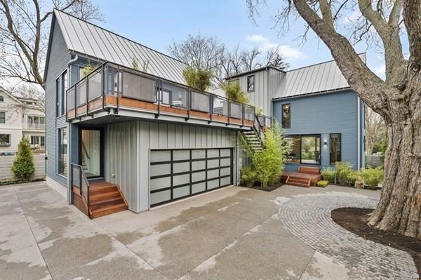 back of house with a garage, metal roof, a standing seam roof, and concrete driveway