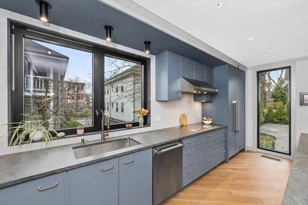 kitchen with visible vents, a sink, light wood-type flooring, under cabinet range hood, and stainless steel dishwasher