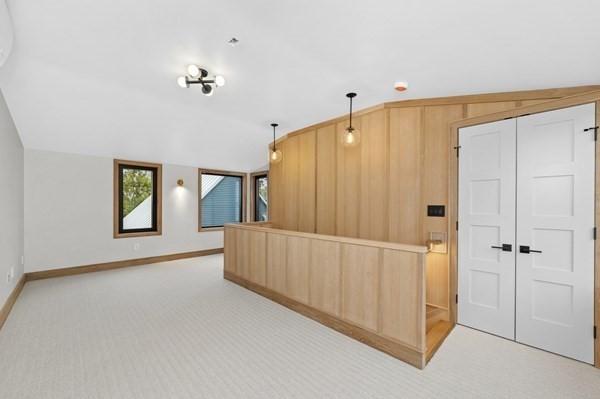 kitchen with pendant lighting, light carpet, vaulted ceiling, and baseboards