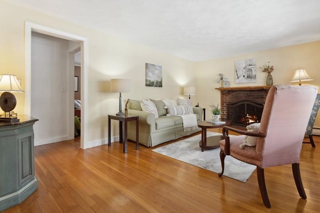 living room featuring a brick fireplace and light hardwood / wood-style floors