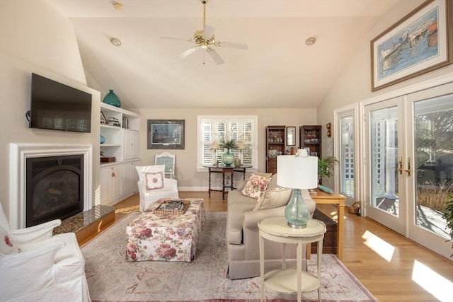 living room featuring ceiling fan, french doors, vaulted ceiling, and light hardwood / wood-style flooring