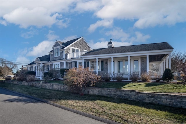 view of front of home with a balcony, a front lawn, and a porch