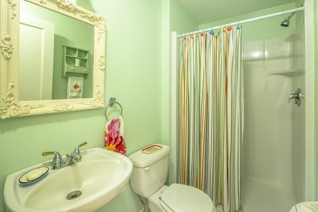 bathroom featuring toilet, curtained shower, and sink