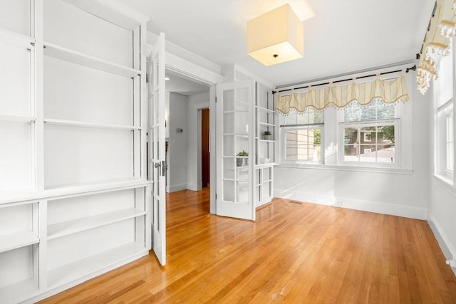 12 Moreland Rd, Quincy, MA 02169 - empty room with light wood-style flooring and french doors