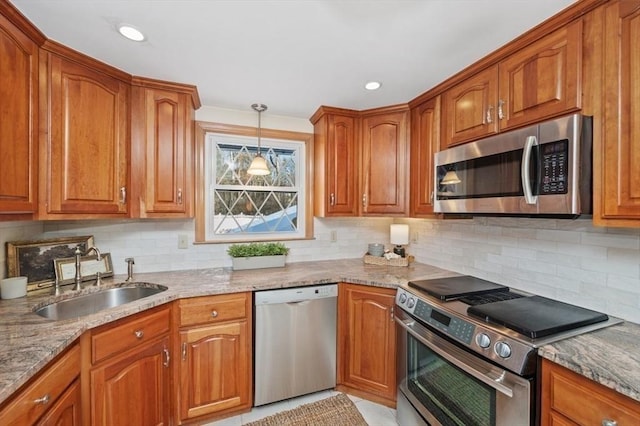 kitchen featuring appliances with stainless steel finishes, sink, backsplash, and light stone counters