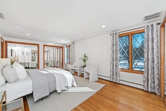 bedroom featuring baseboard heating and wood-type flooring