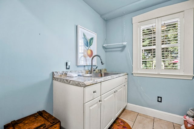 clothes washing area with light tile patterned floors and sink