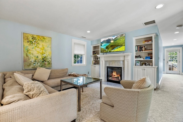 living room featuring built in shelves and light carpet