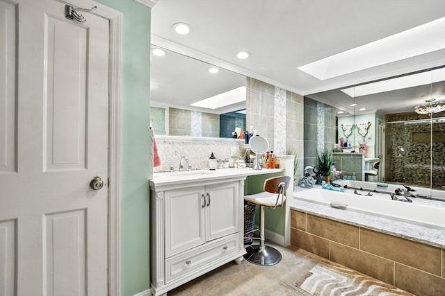 bathroom with a skylight, vanity, plus walk in shower, and tile patterned flooring