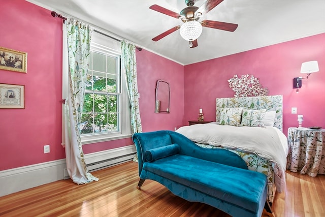 bedroom with baseboard heating, ceiling fan, and hardwood / wood-style flooring