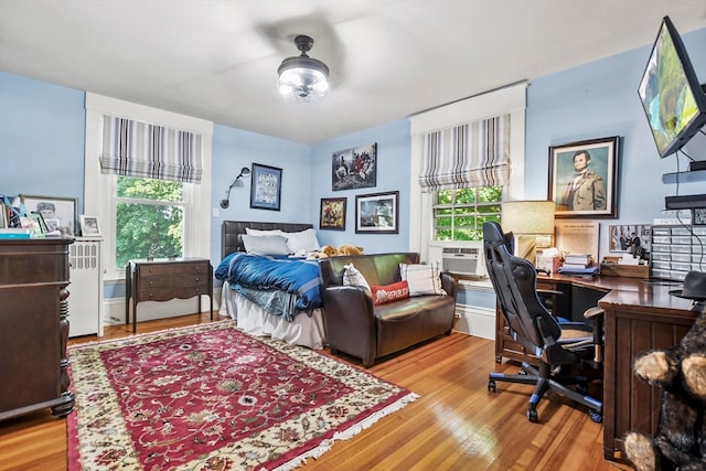 bedroom with multiple windows and light hardwood / wood-style flooring