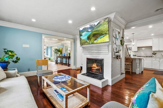 living room with a fireplace, dark wood-type flooring, and crown molding