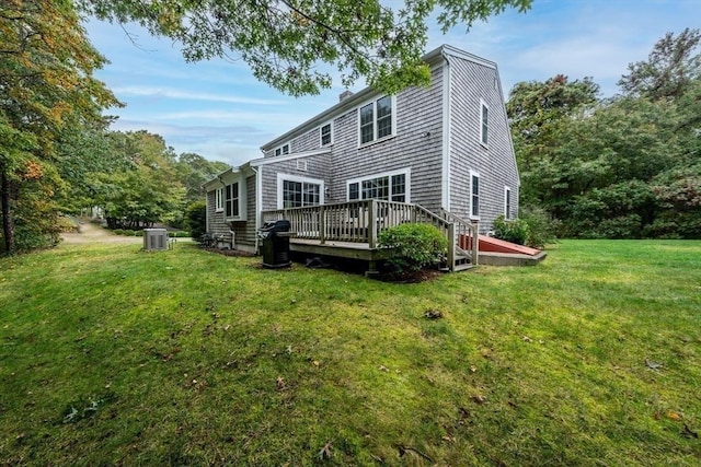 rear view of property with a wooden deck, a yard, and cooling unit