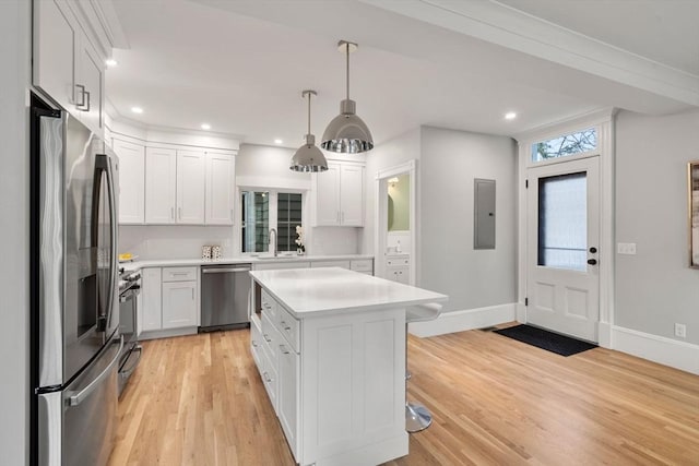 kitchen featuring white cabinetry, light countertops, appliances with stainless steel finishes, light wood-type flooring, and electric panel