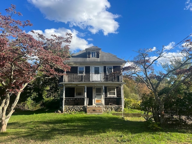 view of front of property with a balcony, covered porch, and a front lawn