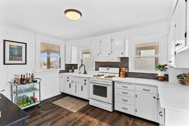 kitchen featuring crown molding, white range with gas cooktop, white cabinetry, and tasteful backsplash