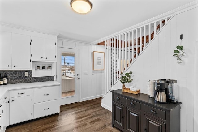 kitchen featuring dark wood-type flooring, decorative backsplash, crown molding, and white cabinets