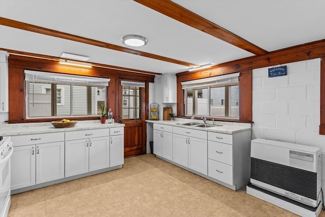 kitchen with white cabinets, beam ceiling, a sink, range, and heating unit