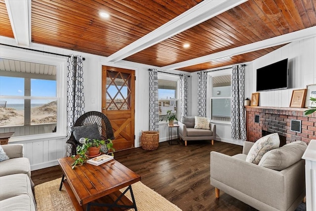living room with wood ceiling, beamed ceiling, a brick fireplace, and dark wood-type flooring