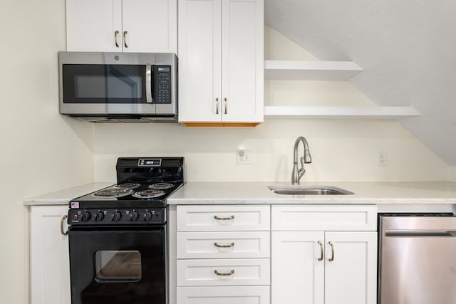 kitchen featuring black range oven, white cabinetry, and sink