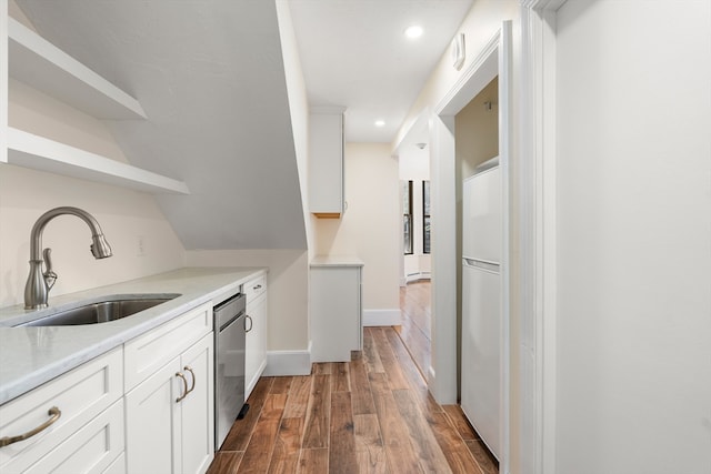 kitchen with stainless steel dishwasher, dark wood-type flooring, sink, white refrigerator, and white cabinets