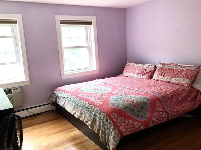 4 Emerson Gardens Rd Unit 4, Lexington, MA 02420 - bedroom with baseboard heating, multiple windows, wood finished floors, and a wall mounted AC