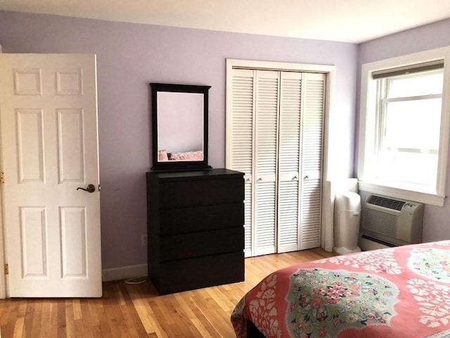 4 Emerson Gardens Rd Unit 4, Lexington, MA 02420 - bedroom with an AC wall unit, light wood finished floors, a closet, and baseboards