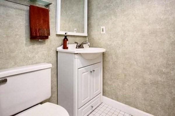 4 Emerson Gardens Rd Unit 4, Lexington, MA 02420 - bathroom featuring toilet, vanity, tile patterned flooring, and baseboards