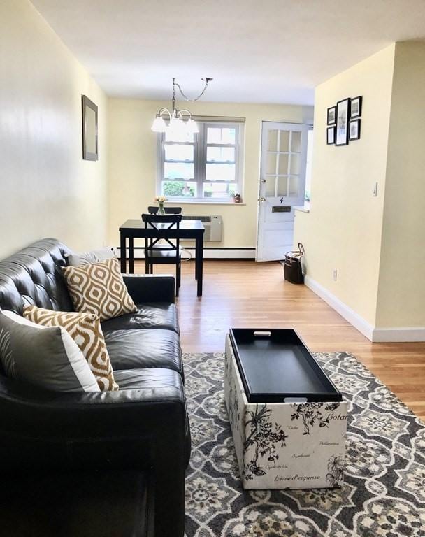 4 Emerson Gardens Rd Unit 4, Lexington, MA 02420 - living room with a chandelier, wood finished floors, and baseboards