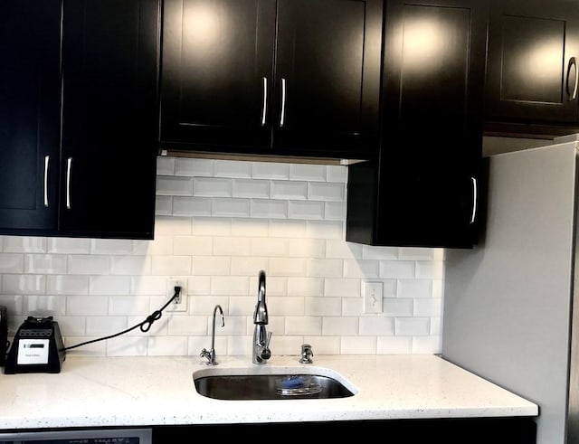 4 Emerson Gardens Rd Unit 4, Lexington, MA 02420 - kitchen with a sink, dark cabinets, tasteful backsplash, light stone countertops, and dishwasher