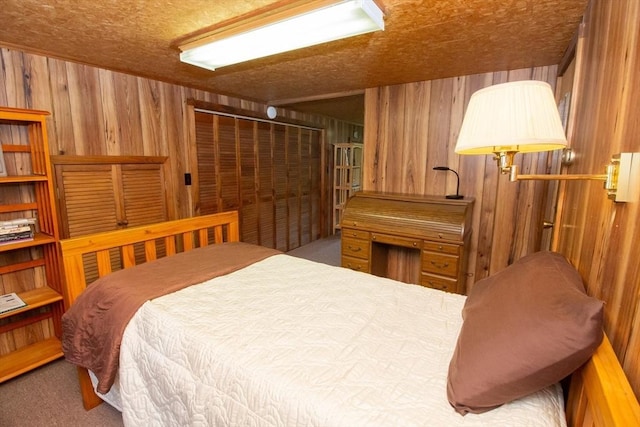 bedroom with carpet, a closet, and wood walls